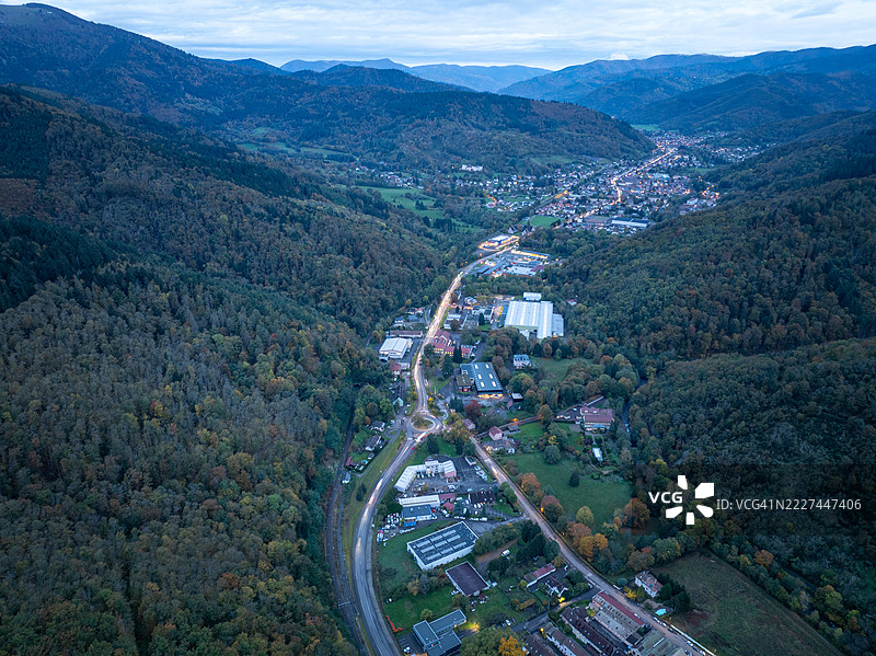 高角度视图，树木和山脉之间的道路，背景是天空，法国大东部地区的坦恩图片素材