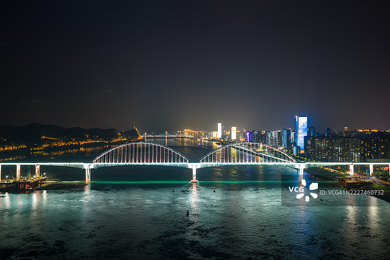 现代桥梁的鸟瞰图，夜间灯光璀璨，现代连接概念图片素材