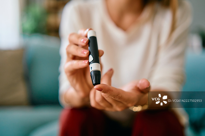 女性在家中使用血糖仪测量血糖水平图片素材