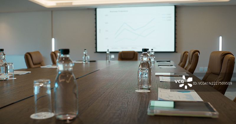 空荡荡的办公室，会议桌上有屏幕和水，适合会议、研讨会或工作坊空间。内部环境空旷，适合进行财务演示、数据分析或企业办公。图片素材