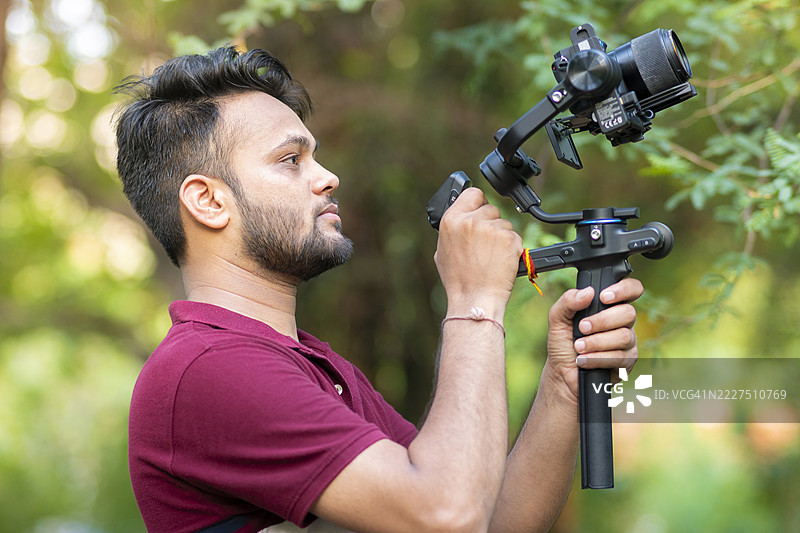 摄像师在大自然中探索并使用相机和稳定器拍摄。图片素材