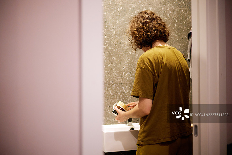 年轻男子在现代简约风格的浴室里洗杯子图片素材