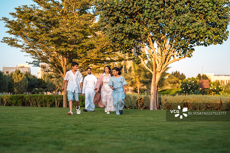 微笑的阿拉伯家庭在繁茂的吉达文化广场散步图片素材