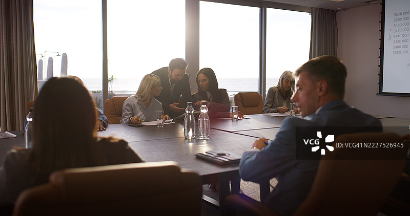 商务人士在办公室开会，使用平板电脑讨论财务、收入信息和问题解决。公司团队在会议室进行技术讨论，进行资金筹集、头脑风暴和财务规划。图片素材
