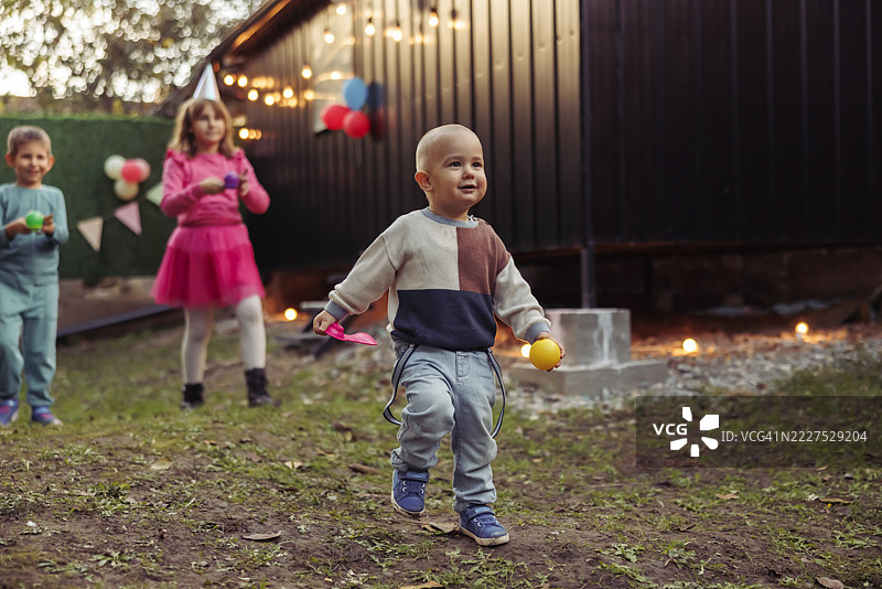 孩子们在户外生日派对上玩蛋与勺比赛，玩得很开心图片素材