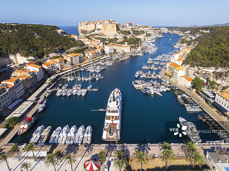 阳光明媚的日子里，科西嘉岛法国博尼法乔的港口和村庄的美丽鸟瞰图图片素材