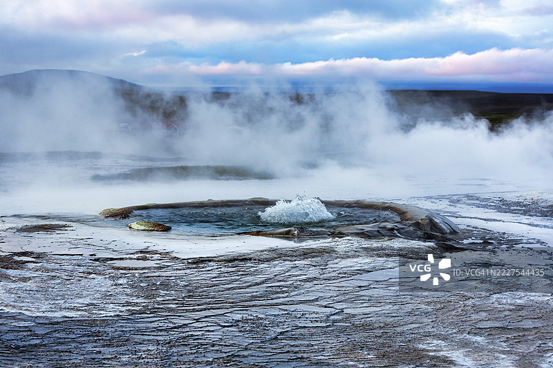 喷泉、硫蒸气、傍晚天空的沉积阶地，赫维拉维尔地热区，冰岛高地，南部地区，冰岛图片素材