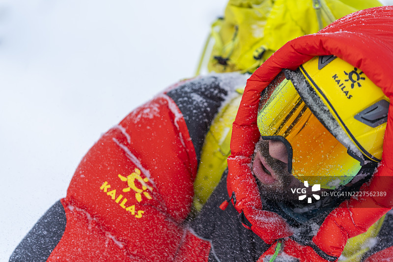 特写冬季登山装备，红色和黄色的冰爬装备在雪中图片素材