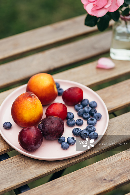 粉色盘子上的桃子、李子和蓝莓图片素材