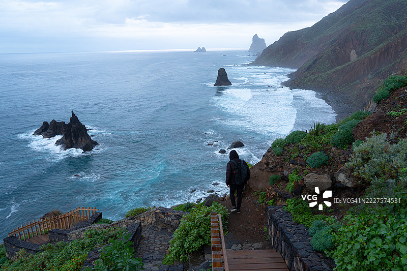 背影男子在海边的台阶上行走，圣克鲁斯-德特内里费，西班牙，加那利群岛图片素材