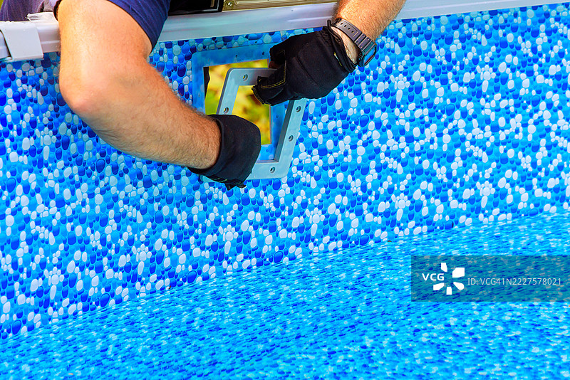 游泳池安装专家为新游泳池进行最后的修整图片素材