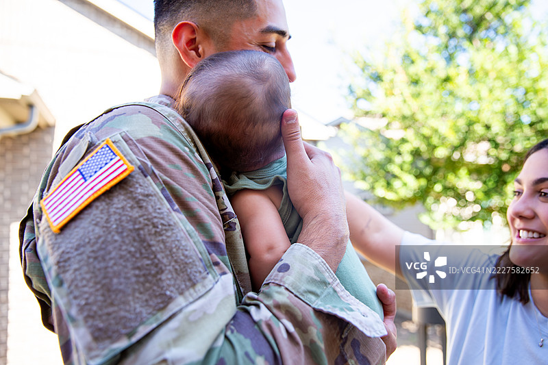 美国陆军退伍军人从军役中归来，与他的新生儿团聚图片素材