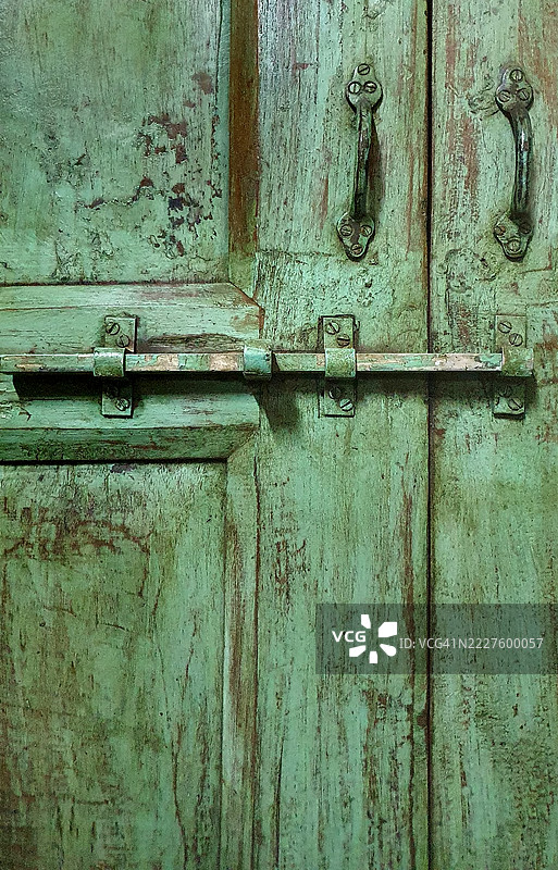 古老绿色木门上的生锈死锁闩图片素材