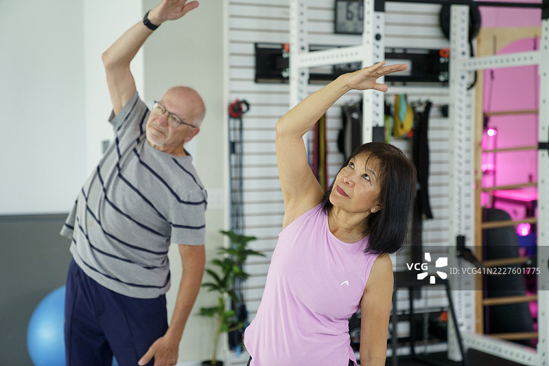 老年夫妇在现代健身房进行健身锻炼图片素材