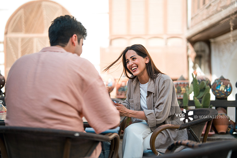 年轻情侣在历史悠久的阿尔巴拉德户外咖啡馆享受轻松的茶歇，欢声笑语。图片素材