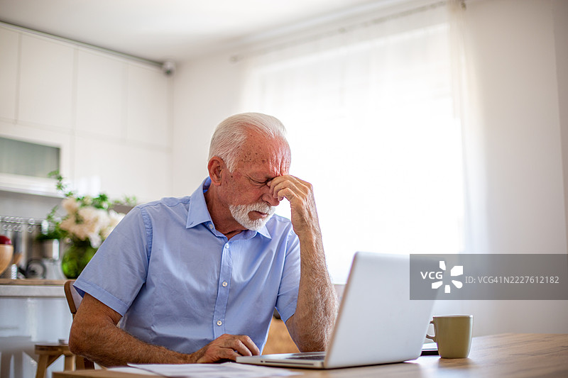 在家工作时感到头痛的老年男性图片素材
