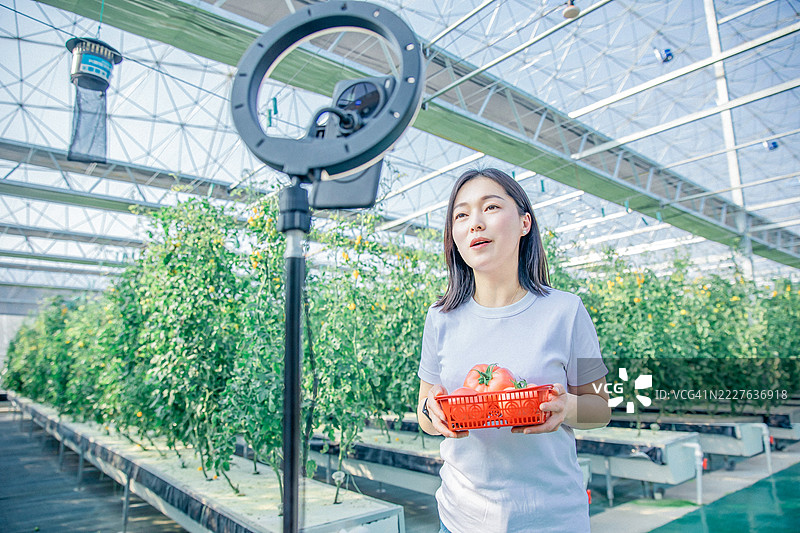 亚洲女性农民正在通过手机进行直播图片素材