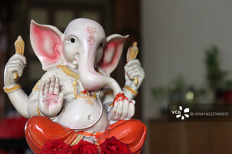 甘尼许（Ganesha）神像特写与红玫瑰花/祝福/甘尼许节（Ganesh Chaturthi）图片素材