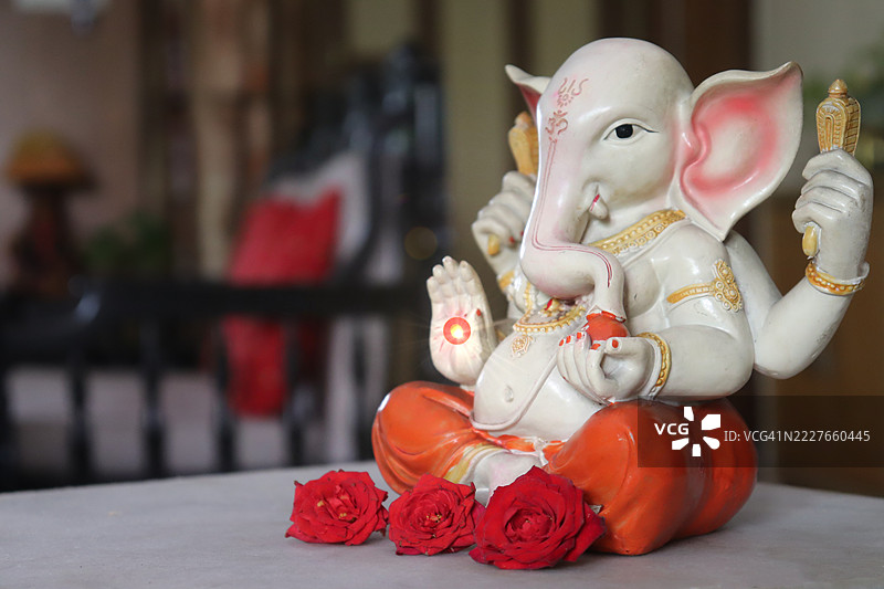 甘尼许（Ganesha）神像特写与红玫瑰花/祝福/甘尼许节（Ganesh Chaturthi）图片素材