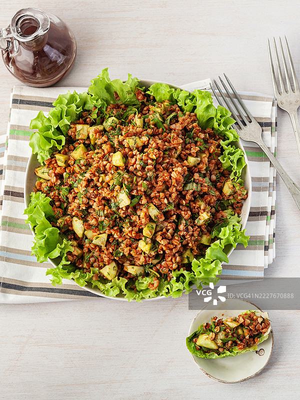 荞麦沙拉。荞麦基西尔。白色碗中盛着煮熟的荞麦和生菜，背景为白色。健康的自制素食。荞麦塔布勒沙拉。传统的中东或阿拉伯菜肴。黎凡特素食沙拉。图片素材