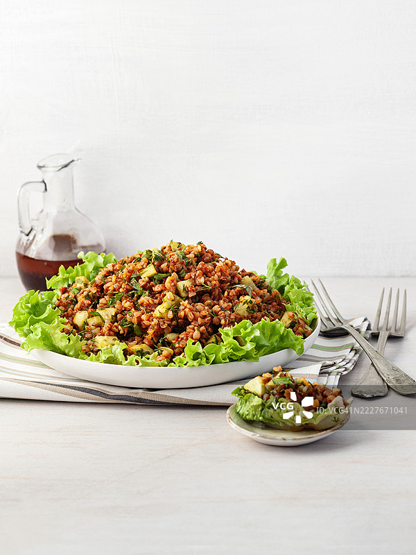 荞麦沙拉。荞麦基西尔。白色碗中盛着煮熟的荞麦和生菜，背景为白色。健康的自制素食。荞麦塔布勒沙拉。传统的中东或阿拉伯菜肴。黎凡特素食沙拉。图片素材