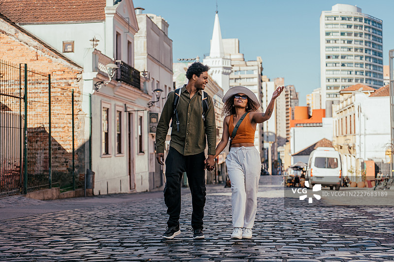 年轻的游客情侣在城市中漫步图片素材