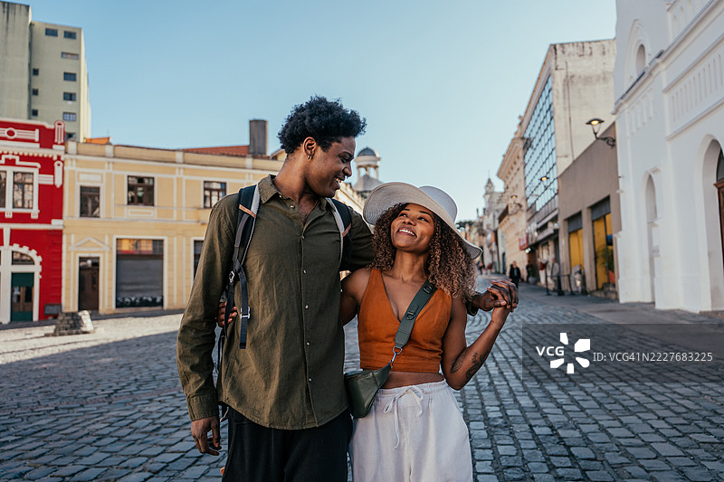 年轻的游客情侣在城市中漫步图片素材