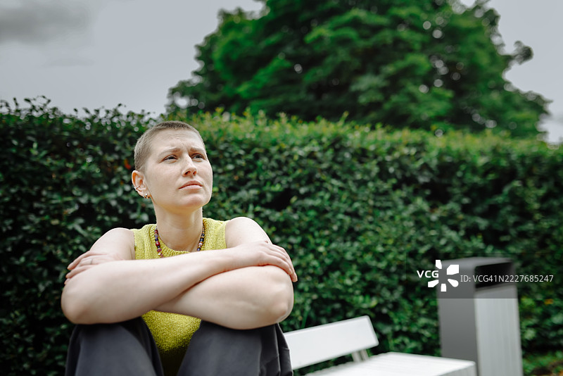 治疗后的恢复，坐在长椅上享受阳光的女性肖像图片素材