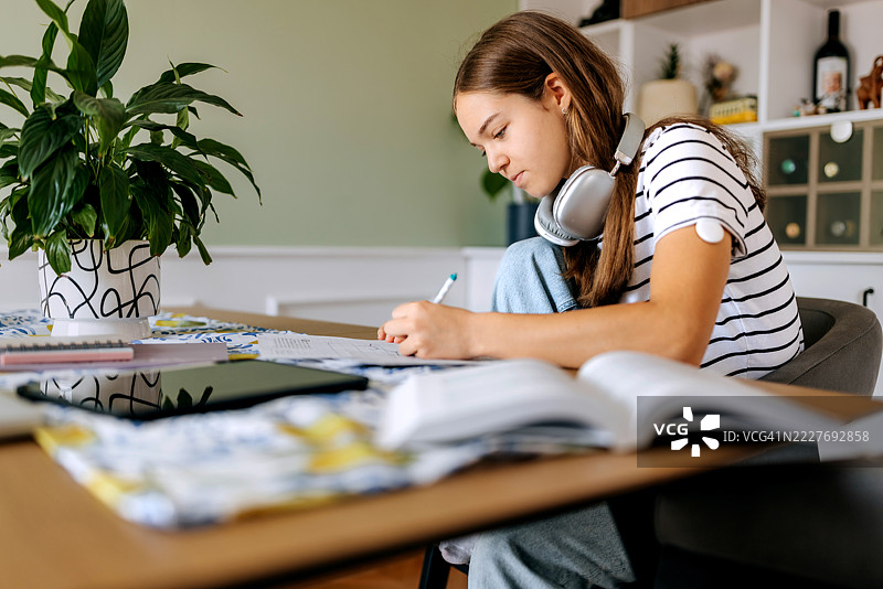 在家做作业的少女，手臂上贴着糖尿病传感器图片素材