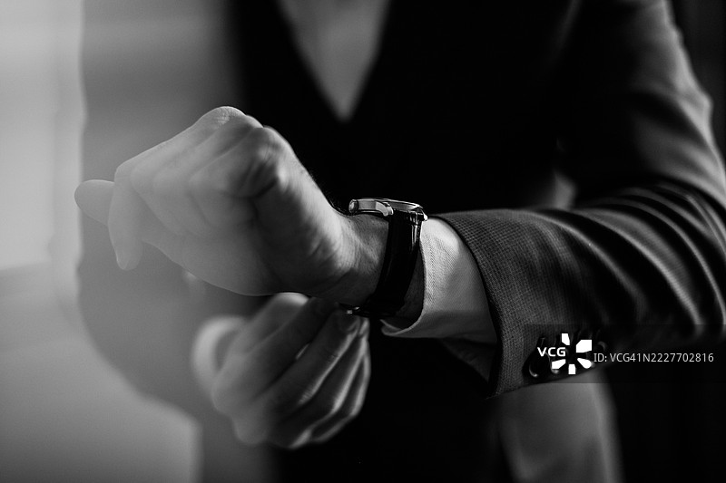 一位兴奋的新郎正在穿衣打扮，准备参加婚礼仪式。图片素材