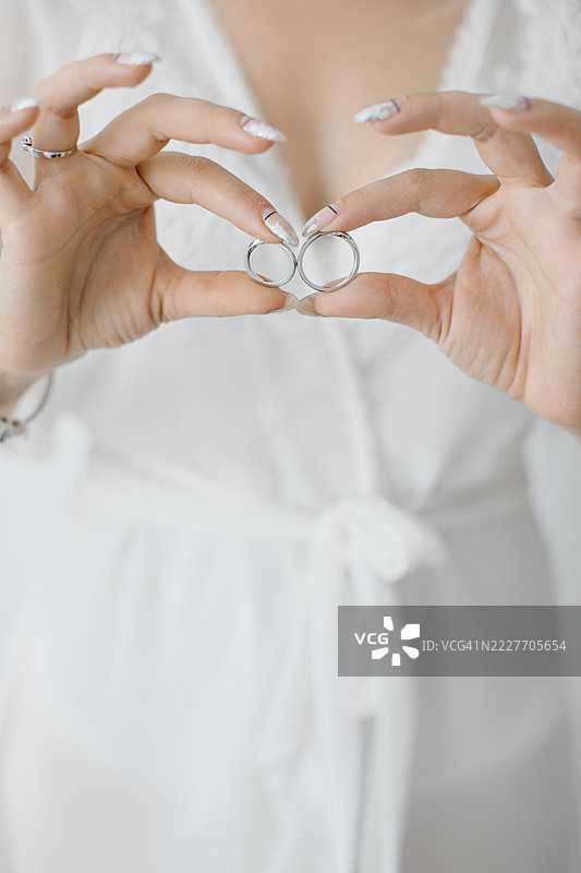 新娘的手展示着婚戒，背景是未来妻子的模糊轮廓。图片素材