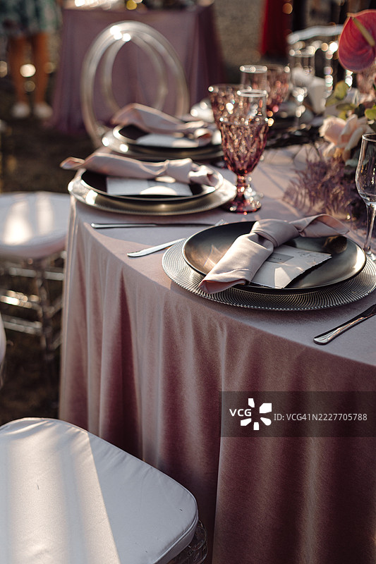 在阳光明媚的豪华餐厅大厅里，摆放着美味佳肴的餐桌。图片素材