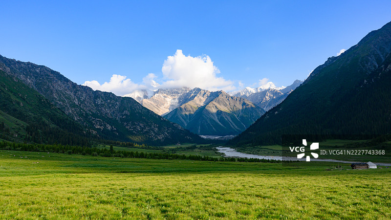 伊犁，新疆维吾尔自治区，中国，田野与山脉的美丽景色映衬着天空图片素材