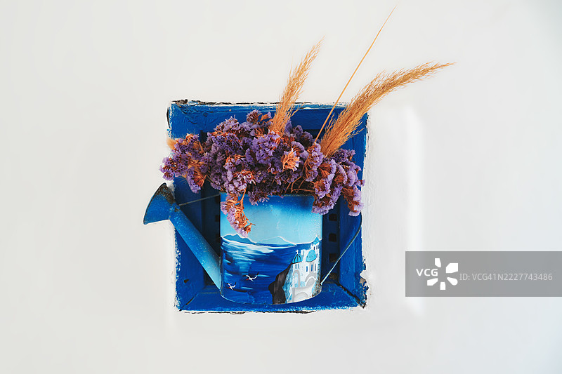 高角度视图的花朵在篮子里，背景为白色，希腊南爱琴海的西夫诺斯岛图片素材