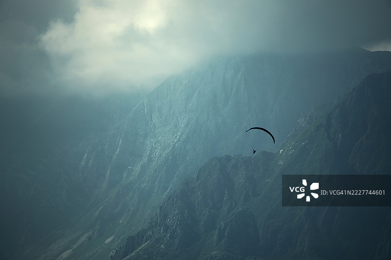 低角度视图的人影在天空中滑翔，托尔敏，斯洛文尼亚图片素材