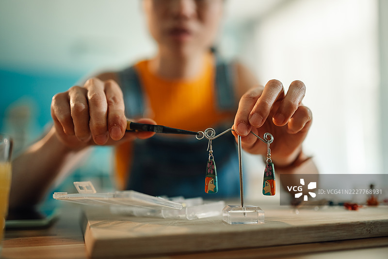 工匠在工作坊里用钳子制作手工耳环图片素材