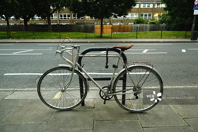 复古自行车停在伦敦人行道上，靠近住宅建筑。图片素材