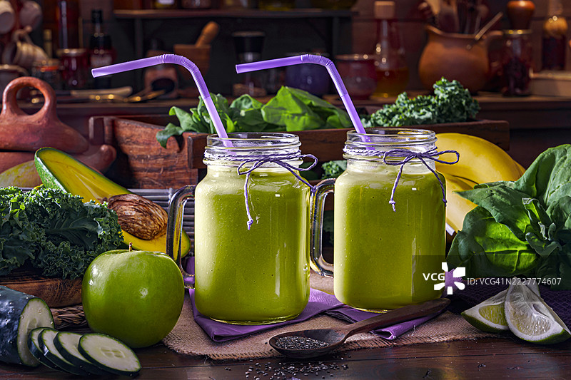 木质桌子上的绿色果蔬冰沙，置于乡村风格的厨房中图片素材