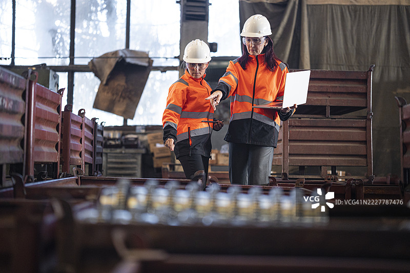 两位工程师在现代工业厂房中讨论图片素材