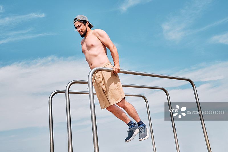 一名约40岁的韩国男子在双杠上做俯卧撑。健身。图片素材