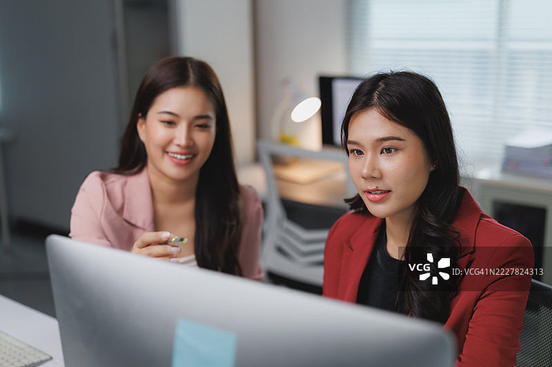 两位年轻女商人在办公室使用台式电脑合作项目图片素材