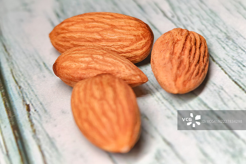 原味整颗杏仁放在粗糙的木质表面上图片素材