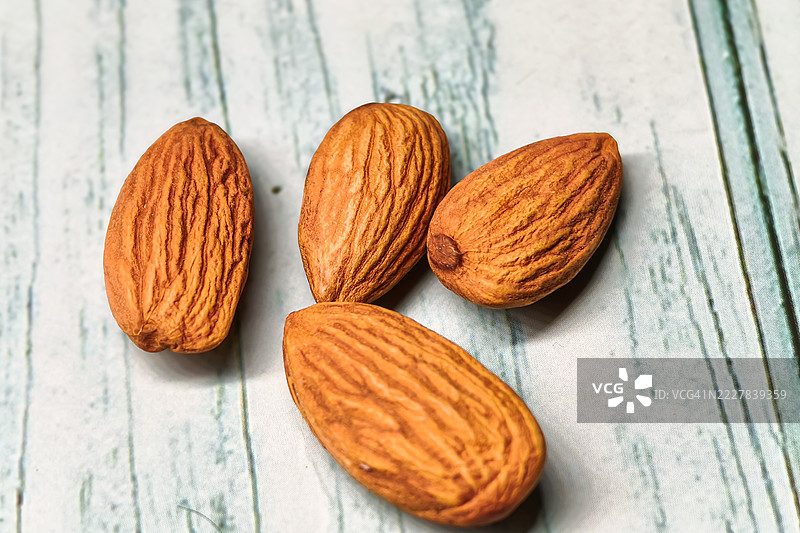 原味整颗杏仁放在粗糙的木质表面上图片素材