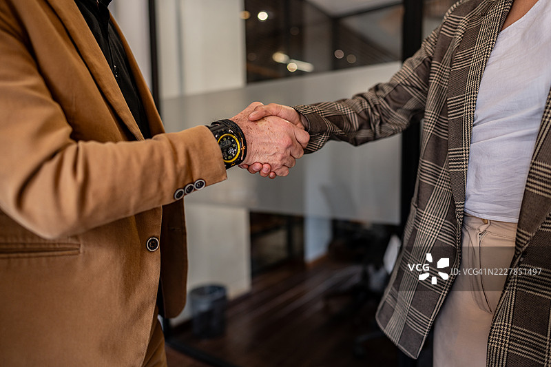 办公室内商务人士握手的特写镜头图片素材