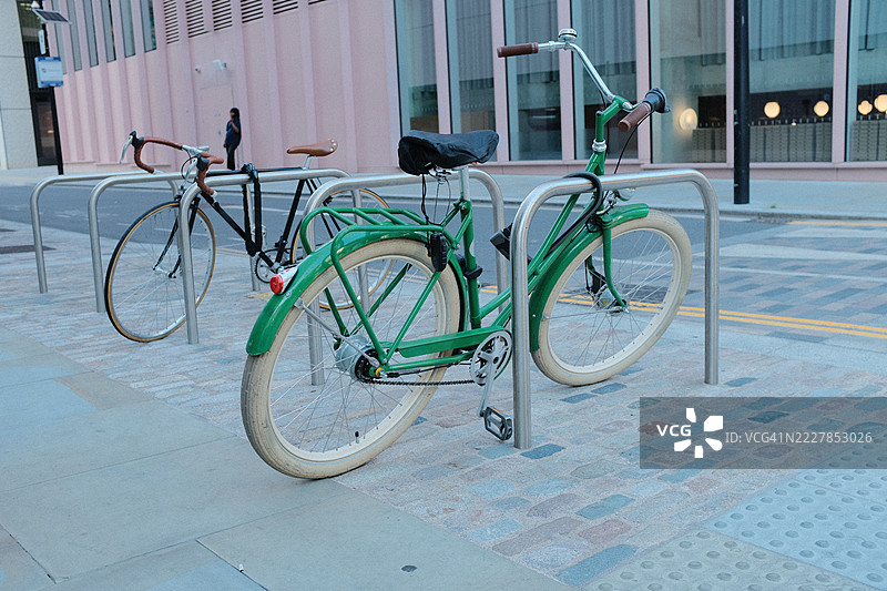 两辆自行车锁在城市人行道上的停车架上图片素材
