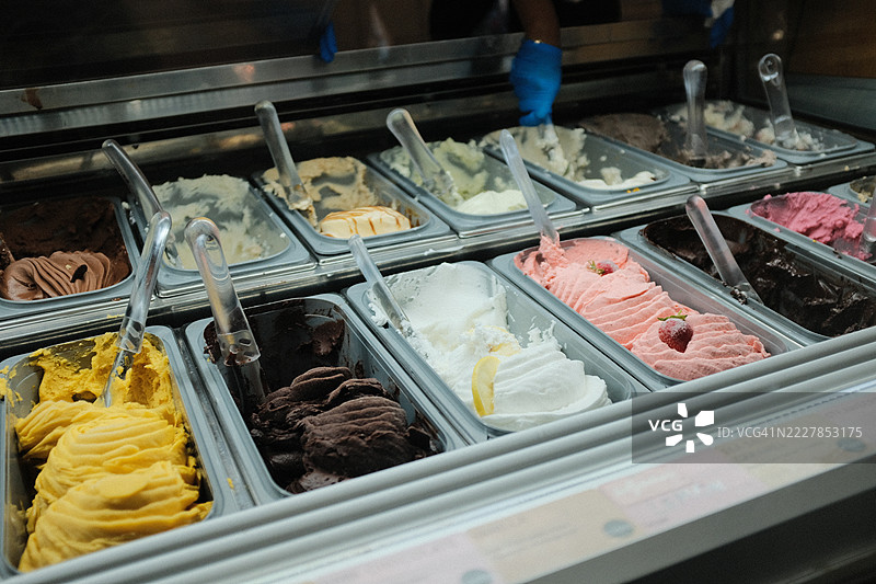 各种色彩缤纷的冰淇淋口味在金属托盘中展示，随时准备上桌图片素材