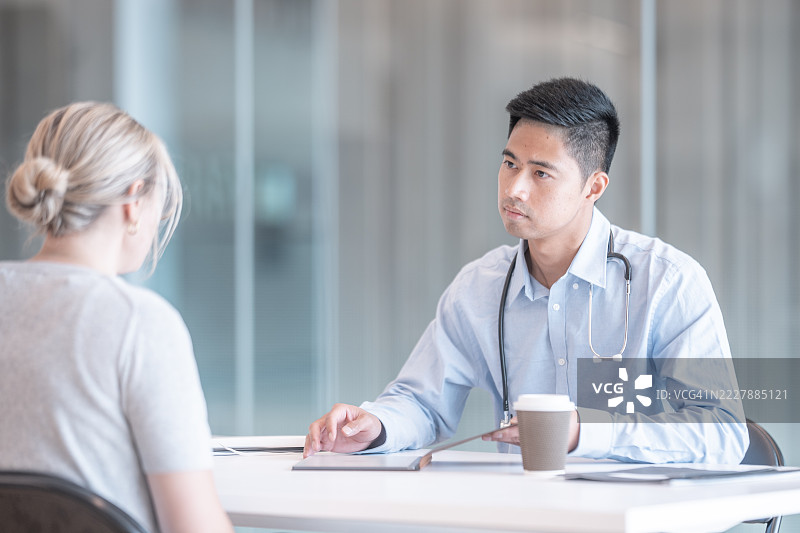 现代办公室环境中医生与患者的专业医疗咨询图片素材