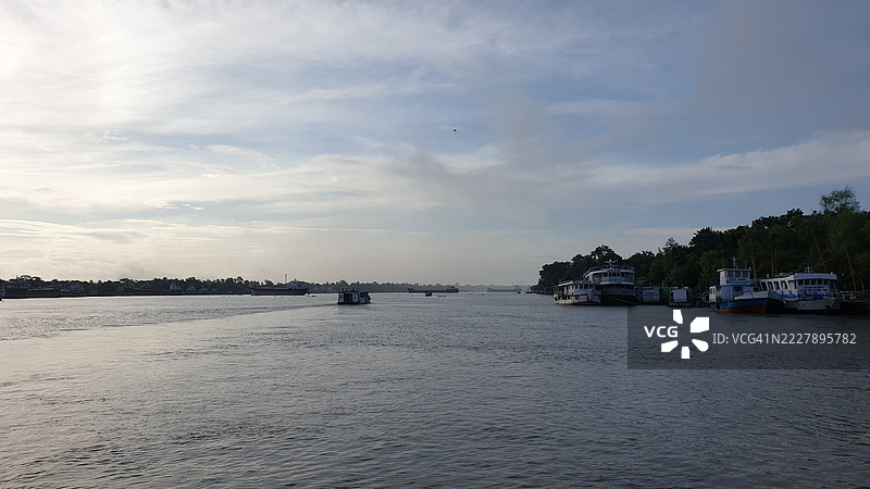 宁静的河流场景，船只与树木，库尔纳，孟加拉国图片素材