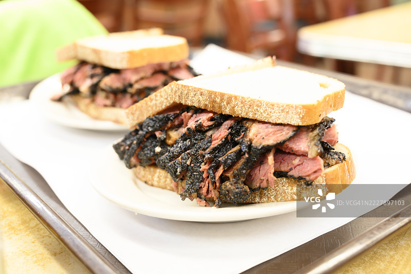 美味的熏肉三明治，搭配一片乡村风格的面包，盛放在盘子里图片素材