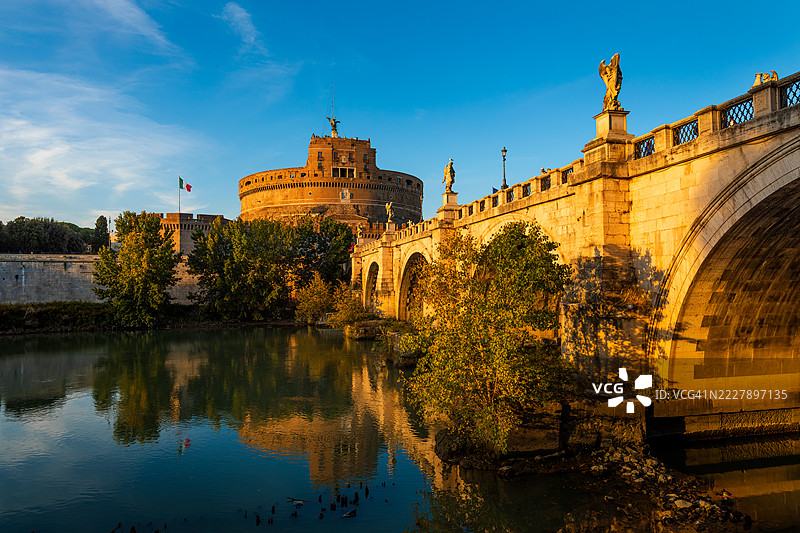 圣天使堡和圣天使桥沐浴在罗马台伯河上的金色光芒中，意大利，罗马，拉齐奥图片素材